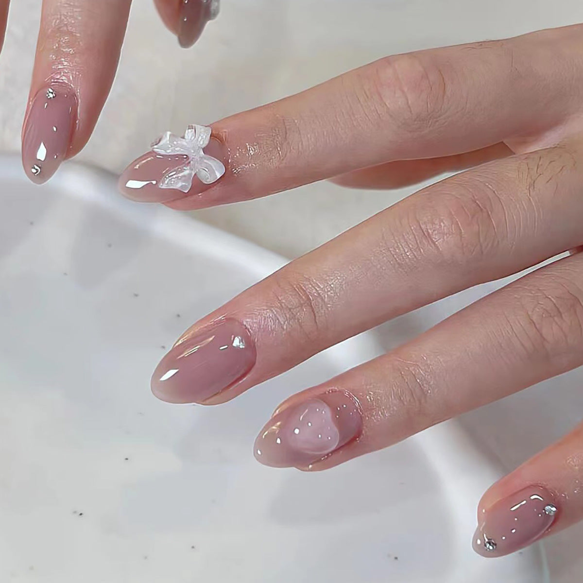 Nude Pink Nails with White Bow and Heart Design